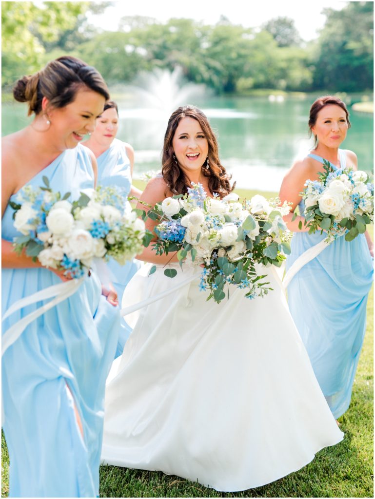 bride and bridesmaid walking in blue dresses and bouquets