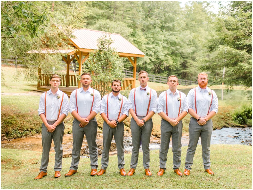 Groom and groomsmen in front of pond