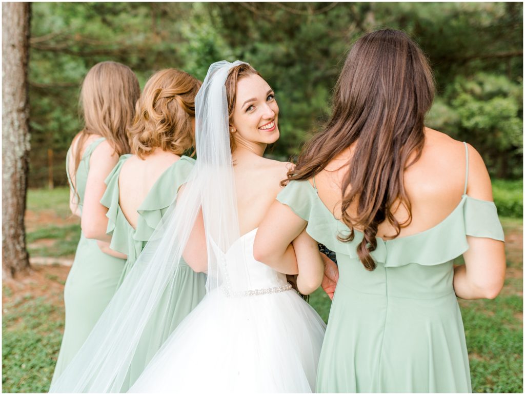 bride looking back and bridesmaids under trees Chapel Hill, North Carolina