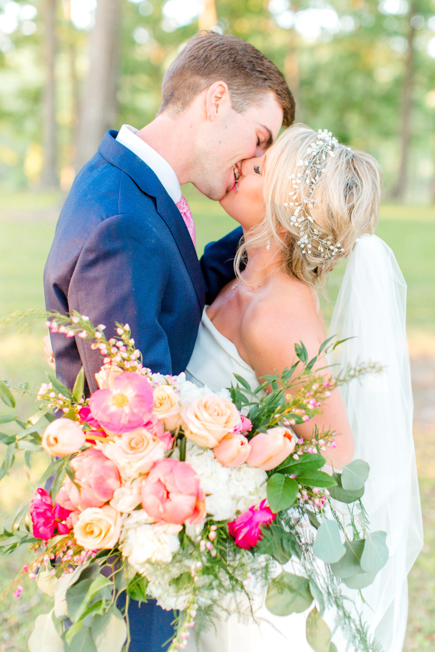 bride and groom kissing with pink bouquet