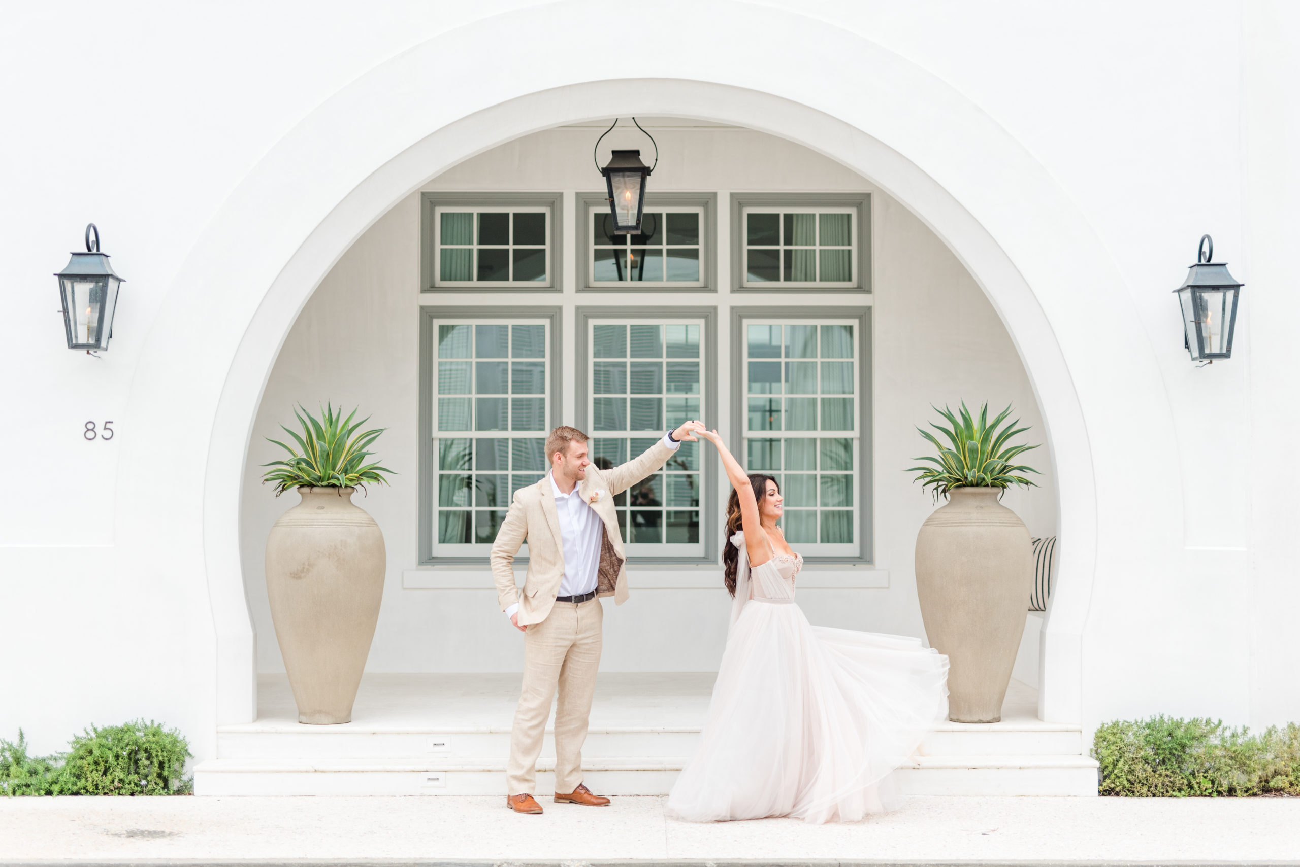 alys beach wedding couple twirling with arch