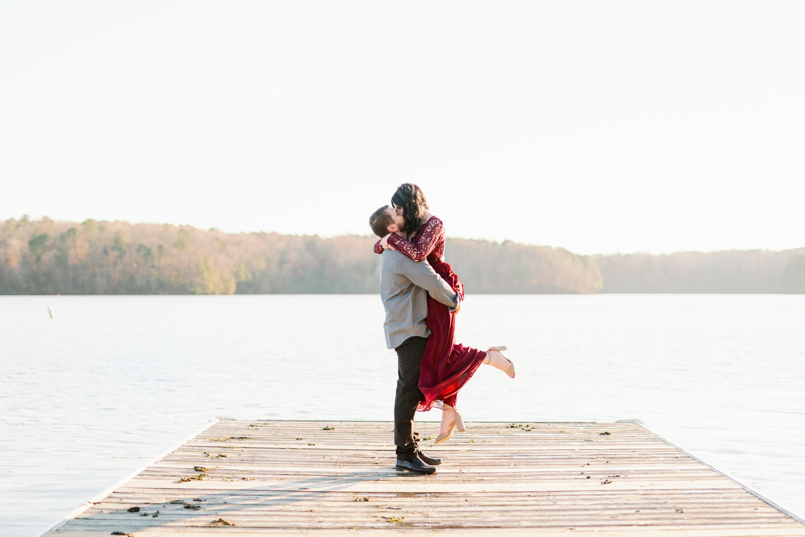 raleigh engagement session couple kissing on dock